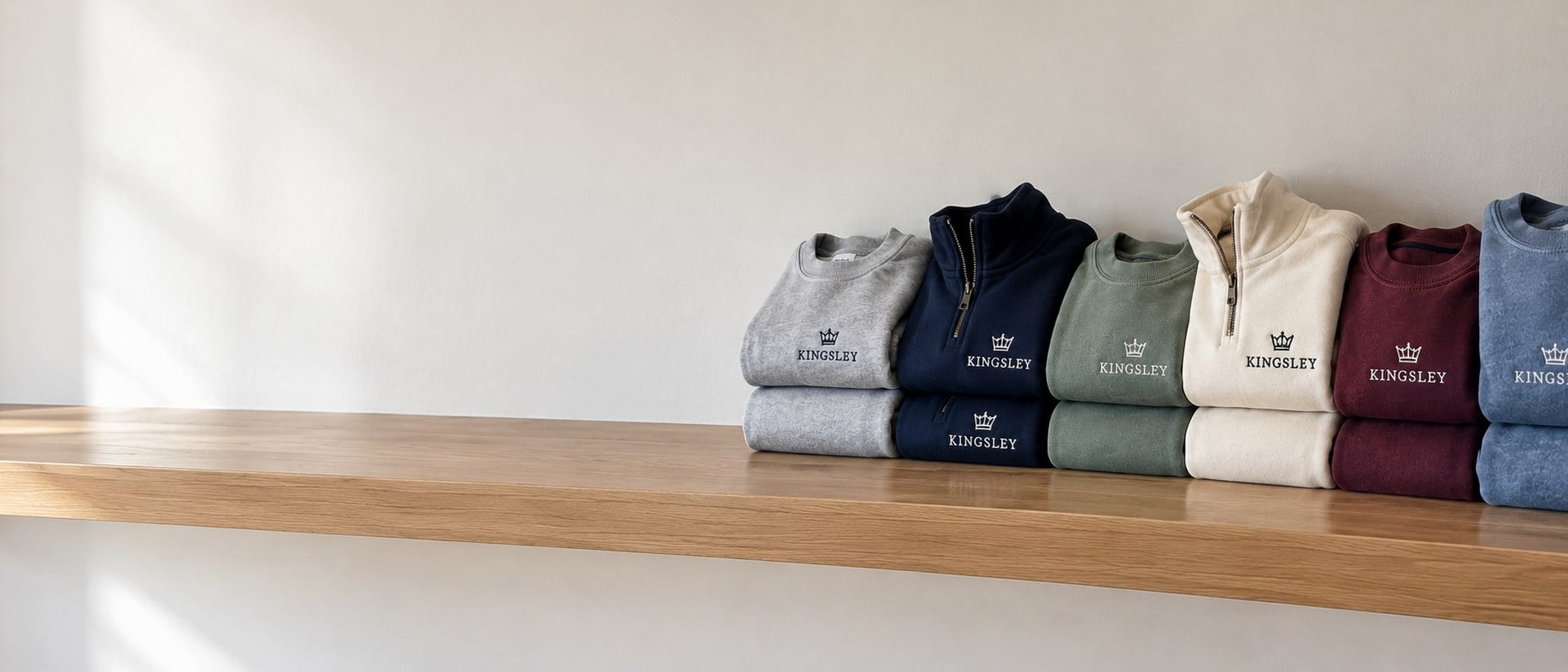 Custom crewneck sweatshirts in bulk folded in stacks on a wooden shelf